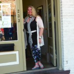 Woman in floral pants standing in doorway.