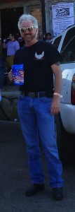 Man in black shirt and jeans holding a cup.