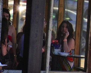 Women gathered around a table, smoking and chatting.