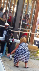 Man playing keyboard with woman in background.