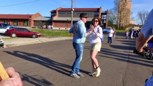 A couple dances in a parking lot.