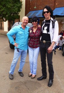 Three people smiling outside a building.