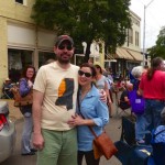 Couple smiles with friends at outdoor event.