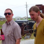 Two men standing with one holding a beer.