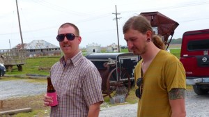 Two men standing with one holding a beer.