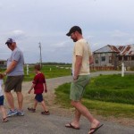 Family walking in front of a rustic building.