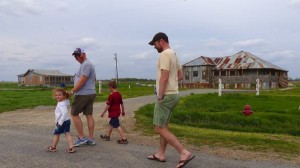 Family walking in front of a rustic building.