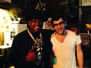 Two men smiling, one wearing a black shirt.