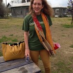 Woman in green shirt with a scarf and a beer.