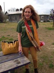 Woman in green shirt with a scarf and a beer.