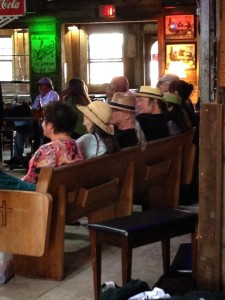 Group of people seated on a wooden bench.