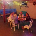 Four people sit around a table in a room.