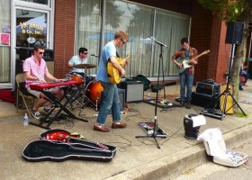 Three musicians playing in a storefront.