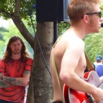 A man playing a guitar at an outdoor event.