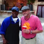 Two men standing together smiling at a party.