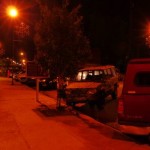 Red pickup truck parked on a street at night.