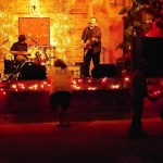 Live band playing on a stage with lights.