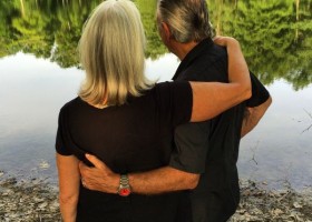 Couple embracing by a lake.