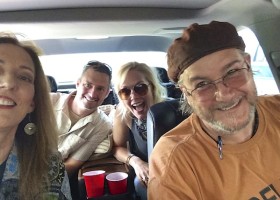 Four friends smiling in a car.