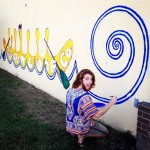 Man painting a mural with a blue spiral.