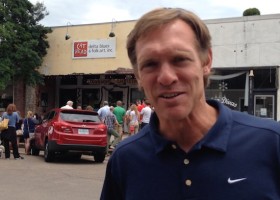 Man in blue polo shirt in front of store.