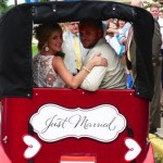 Newlywed couple in a red "Just Married" car.