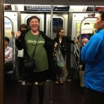 Woman in a green shirt on a subway train.