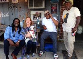 Four people, a dog, and a beer bottle.