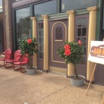 Bar-None sign with red chairs and plants.