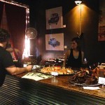 Man serves food at a bar with a woman.