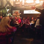 Group of people socializing in a restaurant.