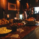 Food and drink spread on a bar table.