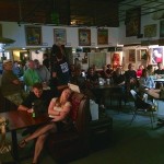 Group of people sitting at tables in a bar.