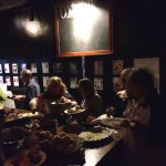 People gathered for a meal in a dimly lit room.