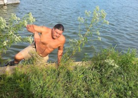 Man in shorts exiting the lake.