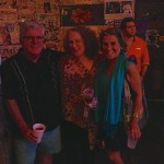 Three friends pose for a photo with drinks.