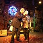 Two men standing in a music club.