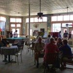 People gather around tables in a cafe.