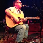 A man playing guitar on stage.