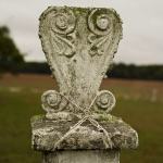 Ornate stone grave marker with rope.