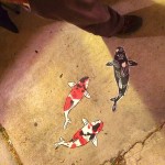 Three koi fish painted on a concrete floor.