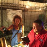 Two people at a fair with a sign.