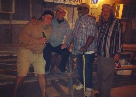 Three men standing outside Red's Blues Club.