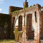 Ruined brick building with ivy growing on it.