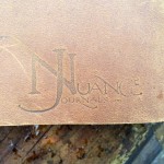 Brown leather journal with "Nuance Journals" logo.