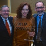 Three people holding an award for Delta.