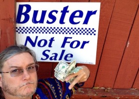 Man holding money near a "Buster not for sale" sign.