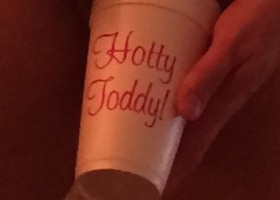 A hand holding a cup that says "Hotty Toddy!"