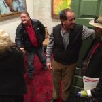 Three men standing in a room, one smiling.