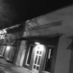 Black and white photo of a building with a sign.